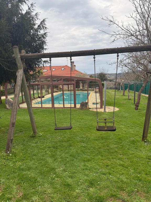 a swing set in a park with a pool at Finca Gonzalez in Deva