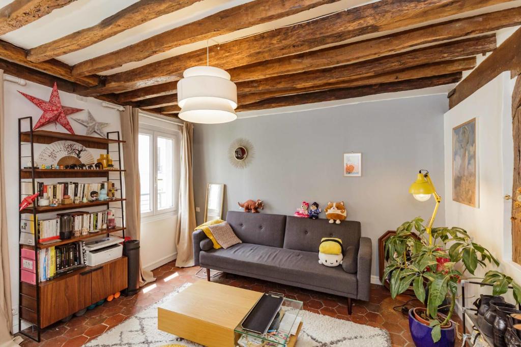 un salon avec un canapé et une étagère dans l'établissement Nice And Bright 40 M For 2 Near Belleville, à Paris