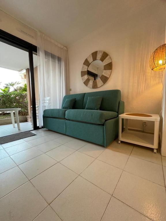 - un salon avec un canapé vert et un miroir dans l'établissement Appartement Cannes, Piscine - Terrasse, Jardin Privatif - 4 Personnes, à Cannes