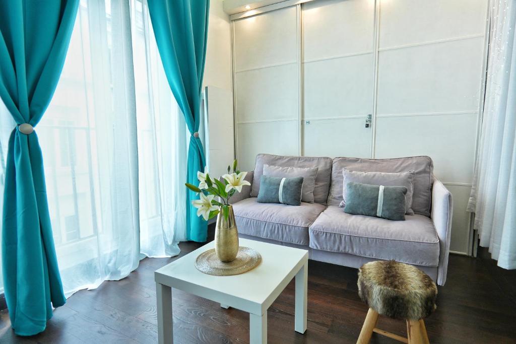 un salon avec un canapé et une table dans l'établissement L'appartement du duc de Choiseul - Coeur Opéra, à Paris