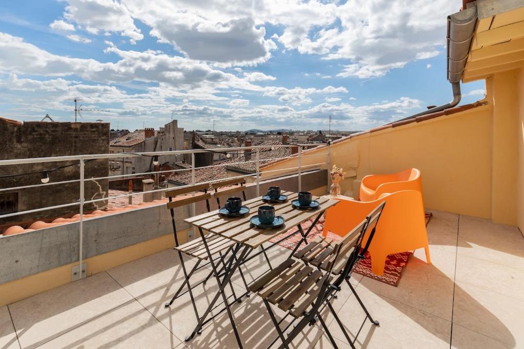 a balcony with a table and chairs on a roof at Le Panorama - Rooftop & Climatisation in Montpellier