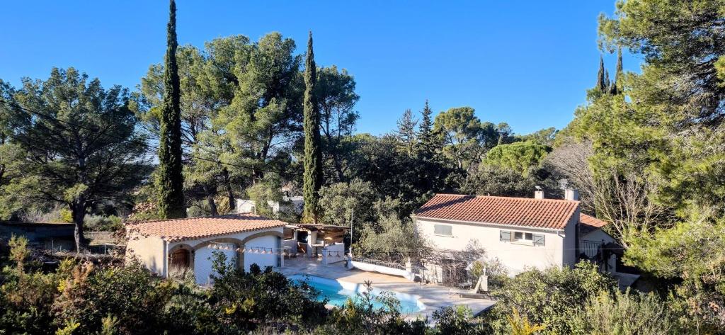 une maison avec une piscine dans une forêt dans l'établissement Villa Provençale Harmonie 8 Guest poolhouse, à Lambesc
