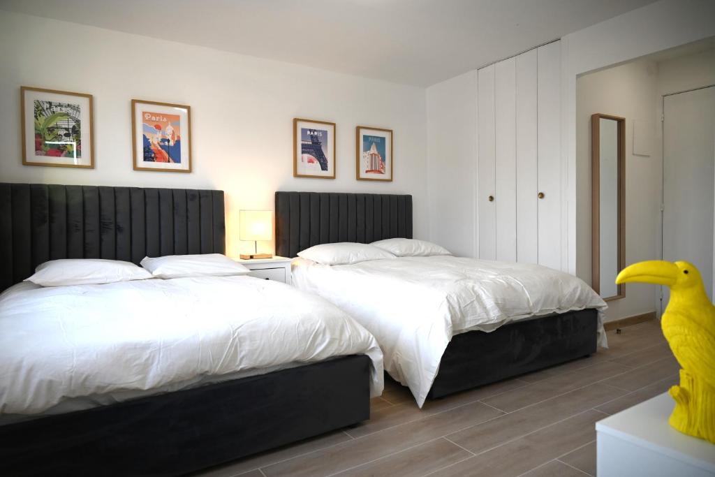 1 dormitorio con 2 camas y una estatua de pato amarillo en Studio Paris, en Ivry-sur-Seine