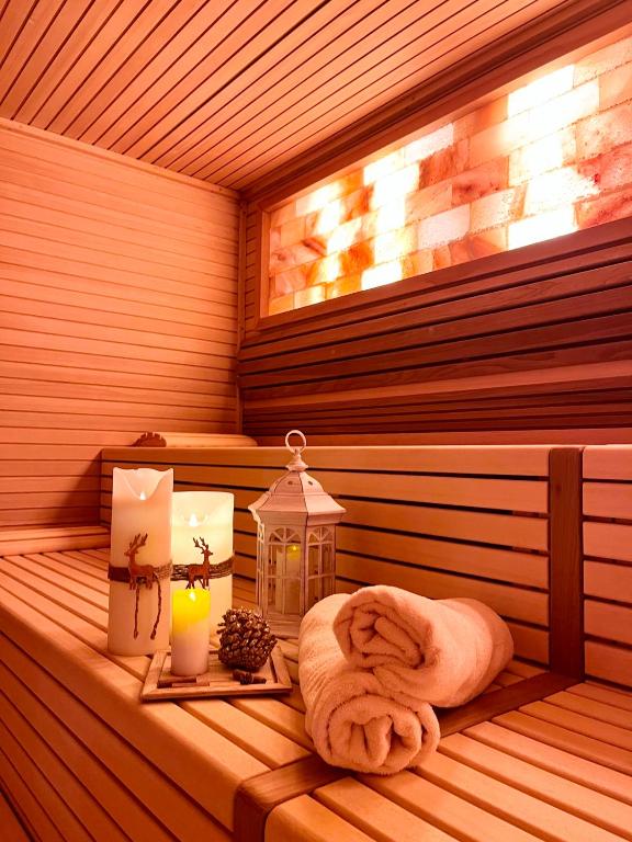 a sauna with a towel and candles and a lantern at Hotel Europa in San Martino di Castrozza