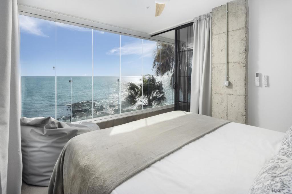 a bedroom with a bed and a large window with the ocean at Perla Negra - Apartment with Private Beach Access in Benalmádena