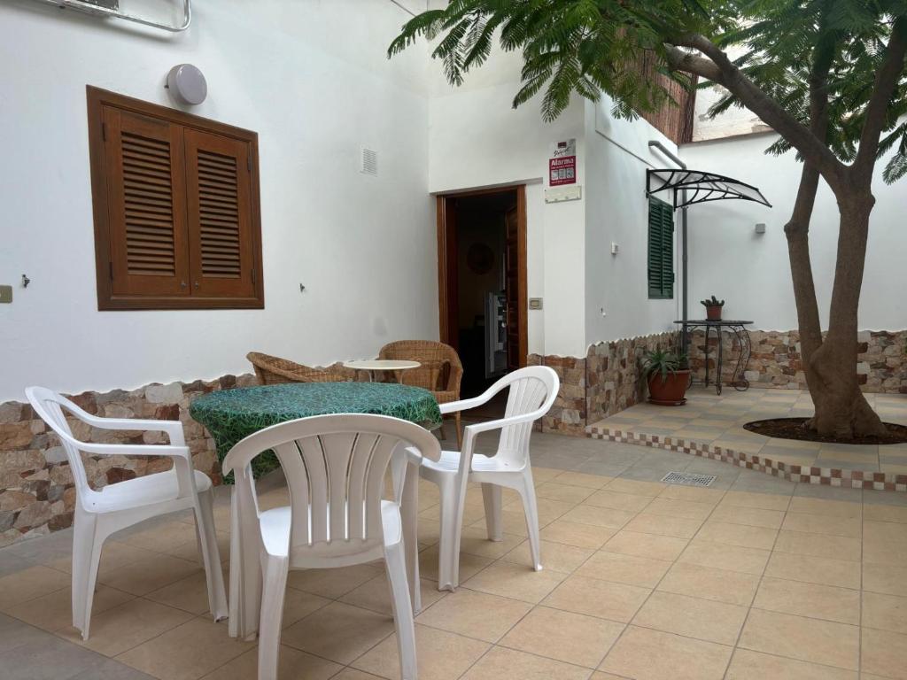 ein Tisch und Stühle in einer Terrasse mit einem Baum in der Unterkunft Sweet Life in Costa Del Silencio