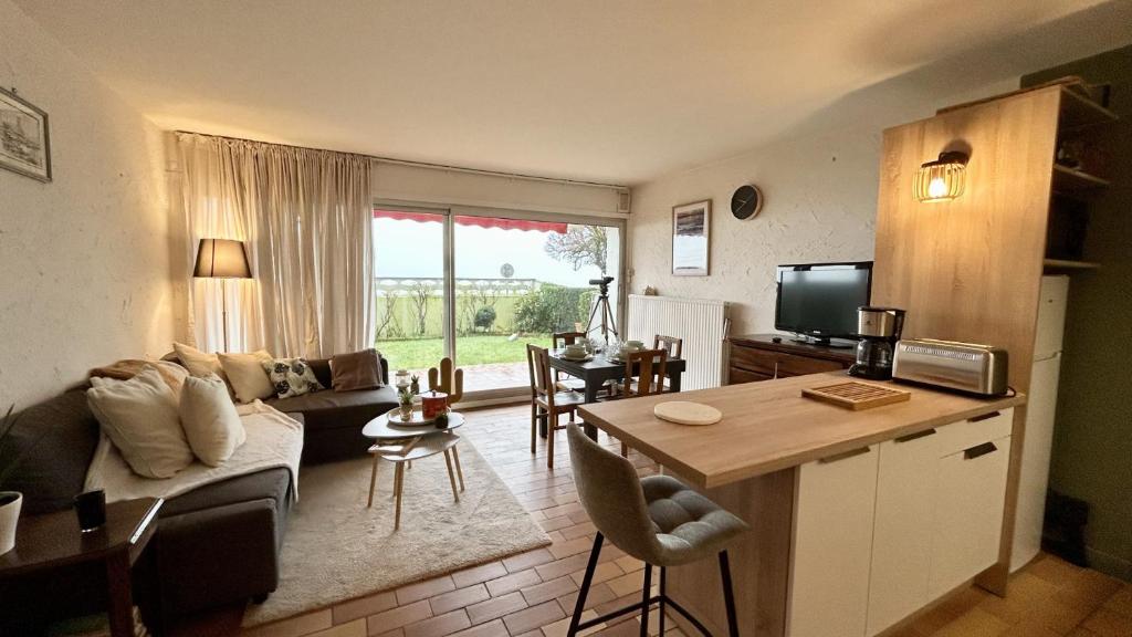 un salon avec un canapé et une table dans l'établissement JArdin sur Baie, appartement vue mer, au Crotoy