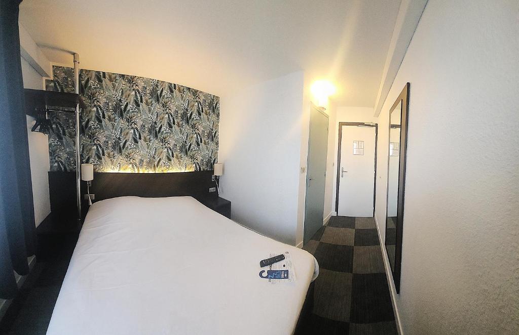 une chambre avec un lit blanc dans une pièce dans l'établissement Hôtel Inn Design Resto Novo Langres, à Langres