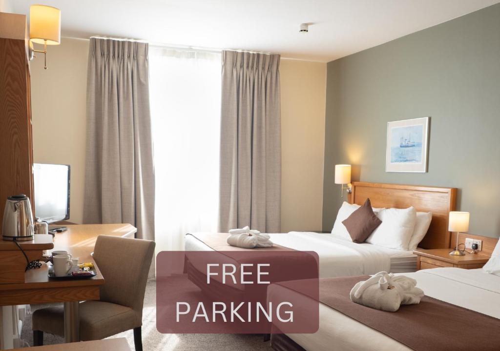Una habitación de hotel con dos camas y un cartel de aparcamiento gratuito. en Future Inn Cardiff Bay, en Cardiff