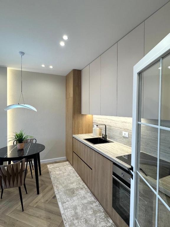 een keuken met een tafel en een eetkamer bij Downtown Shkodra Apartment in Shkodër