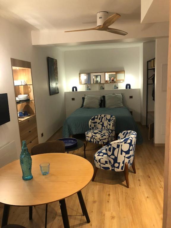 une chambre avec un lit, une table et des chaises dans l'établissement your studio in Collioure, à Collioure