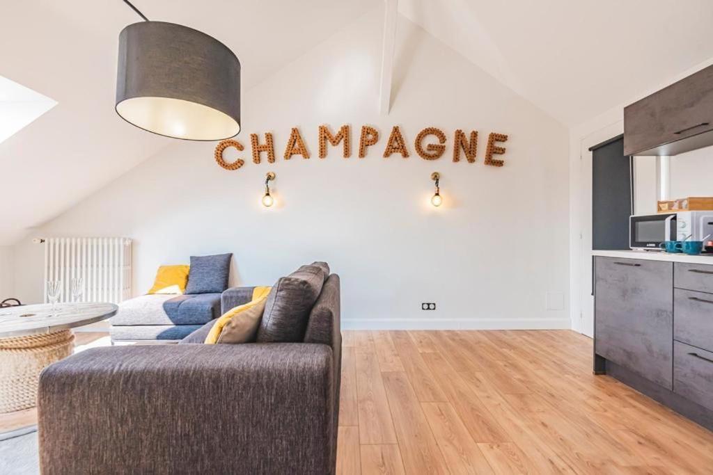 - un salon avec un canapé et un panneau qui lit du champagne dans l'établissement Suite Champagne, à Épernay