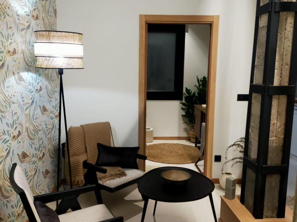 Una sala de estar con una silla y una mesa. en Alojamiento Beach Riazor, en A Coruña