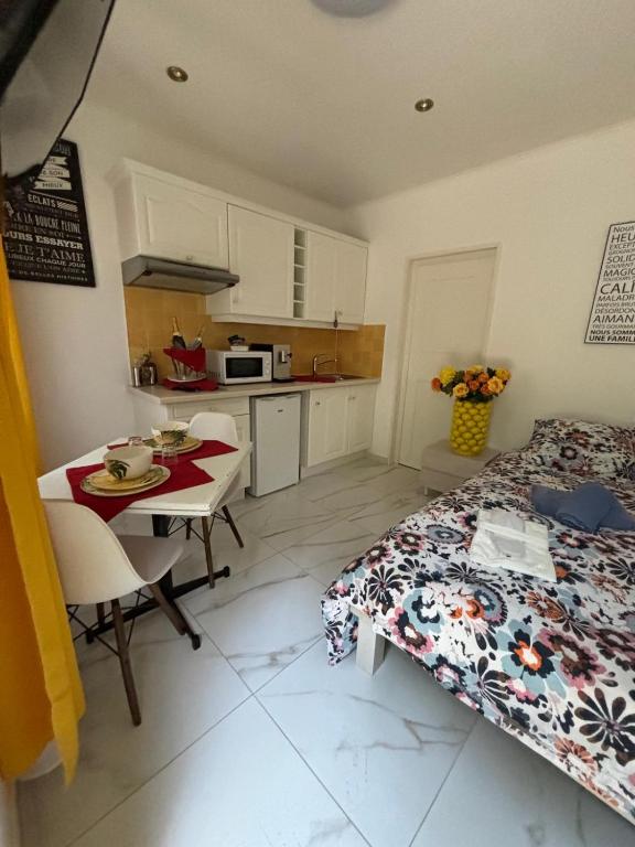 une chambre avec un lit et une table et une cuisine dans l'établissement Marie Studio COSY, à Sanary-sur-Mer
