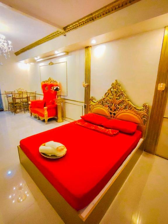 a bedroom with a red bed and a red chair at Palacio in Kaybagal