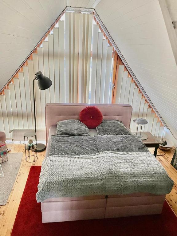 a bedroom with a bed with a red pillow on it at Bel Art Atelier mit großem Parkplatz in Haan