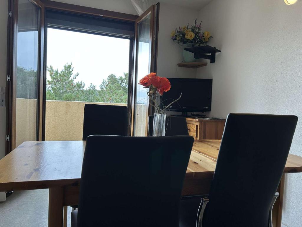 une table à manger avec des chaises et un vase de fleurs dans l'établissement SP430-635 Appt 2 pièces 4 couchages SAINT PIERRE LA MER, à Saint Pierre La Mer