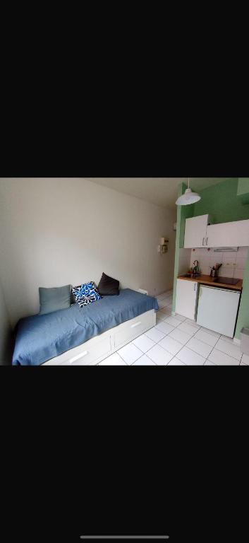 une chambre avec un canapé bleu dans l'établissement Studio dans le centre ville !, à Bourges