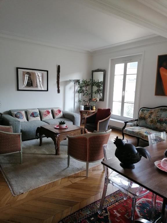 un salon avec un canapé et une table dans l'établissement Bel appartement Hausmannien au centre de Paris, à Paris