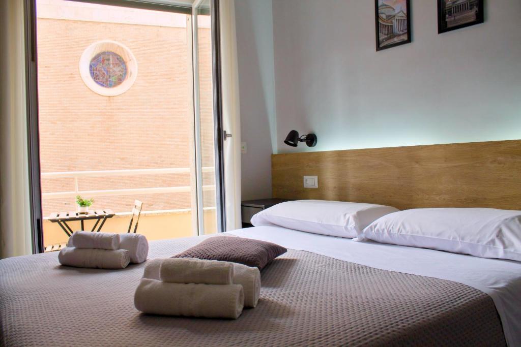 a bedroom with two beds and a large window at Napoli Vitale Apartments in Naples