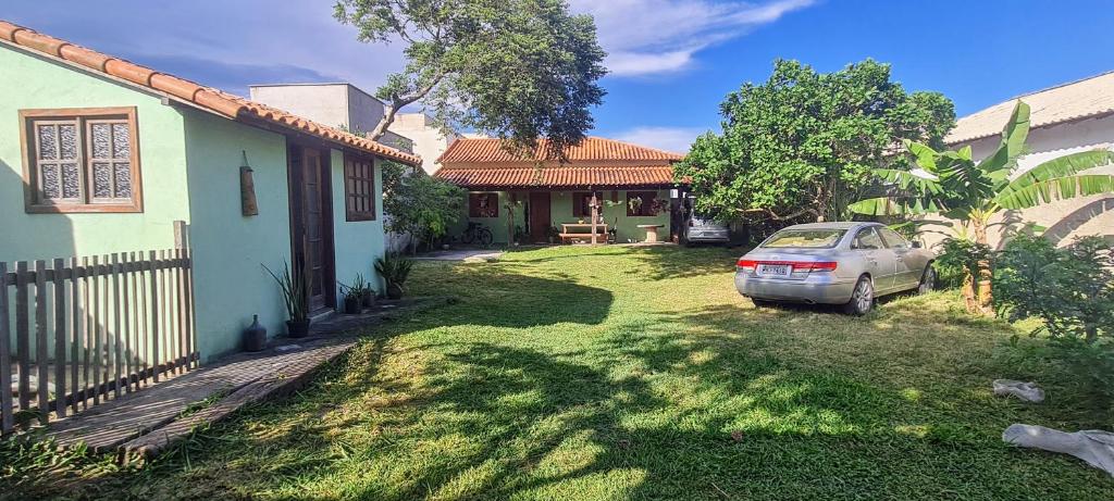 a car parked in a yard next to a house at Studio - Casa da Restinga in Cabo Frio