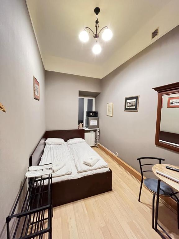 a bedroom with a bed and a table and chairs at Freska Apartments in Lviv