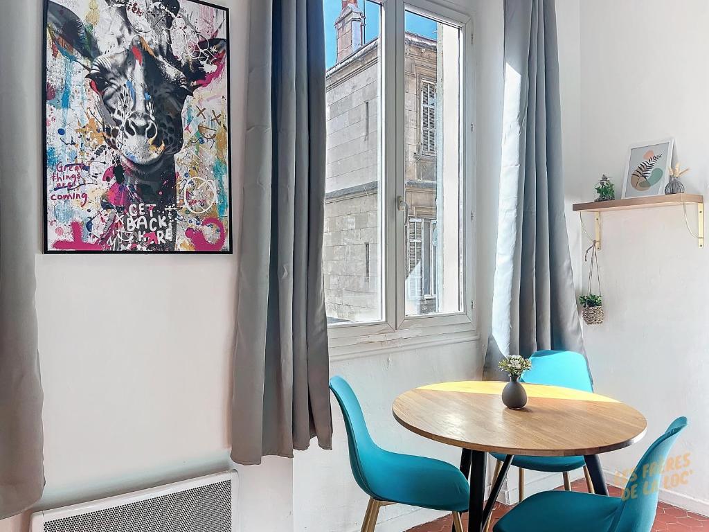 une salle à manger avec une table et des chaises et une fenêtre dans l'établissement Appartement Lumineux - Cours Julien - Les Frères de la Loc', à Marseille