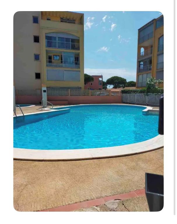 une grande piscine bleue devant un immeuble dans l'établissement Superbe 2 pièces climatisé avec piscines, à Gruissan