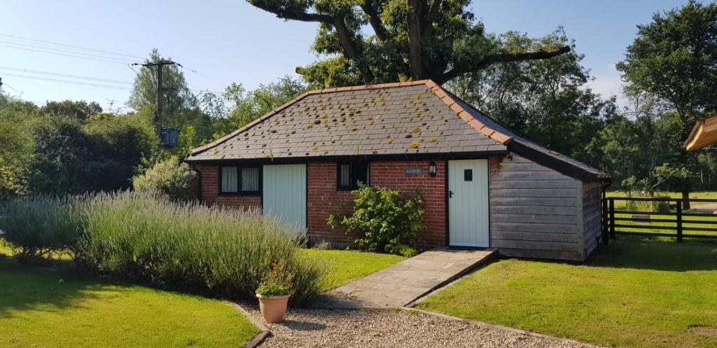 a smallshed with a white door in a garden at Acorns in Plaitford