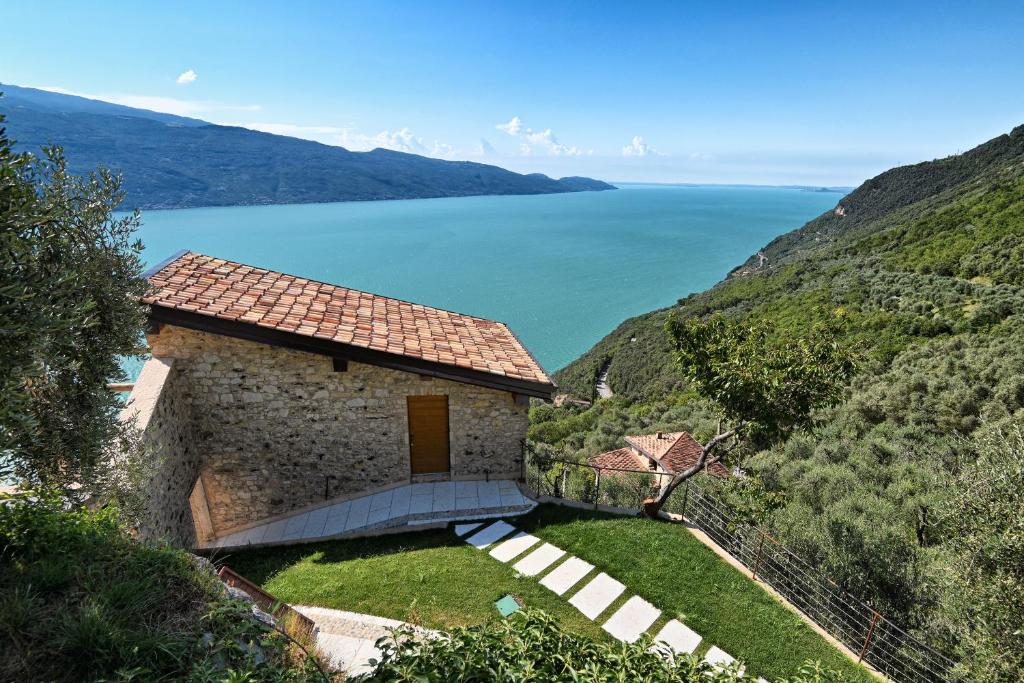a building on a hill with a view of the water at Casa Limonaia al Pos in Tignale