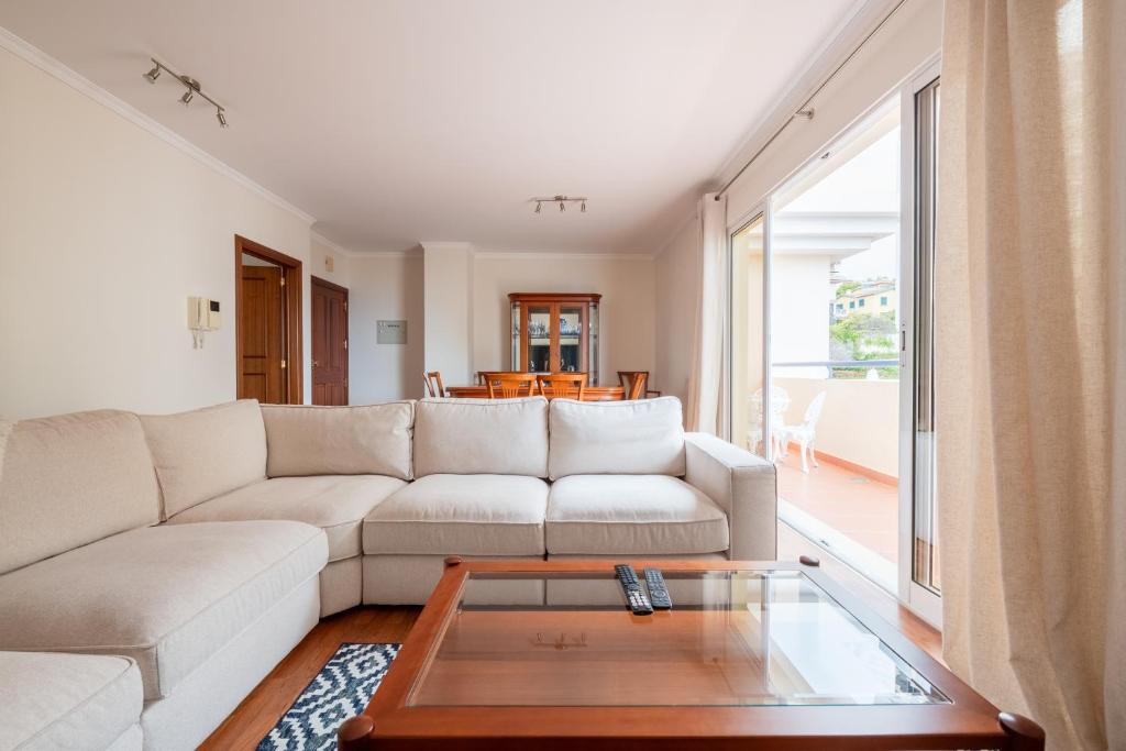 a living room with a white couch and a coffee table at Madeira Sunny Penthouse in Funchal