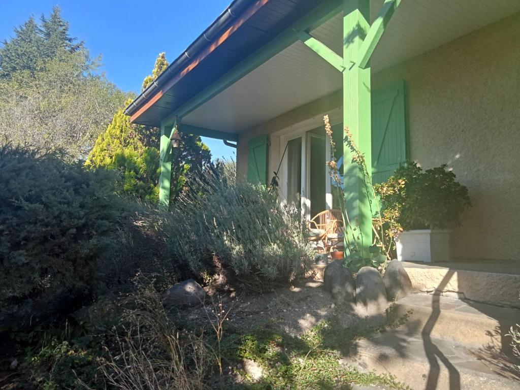 una casa con una croce verde sul lato di Charmante maison près de la forêt de châtaigniers a Ceyrat