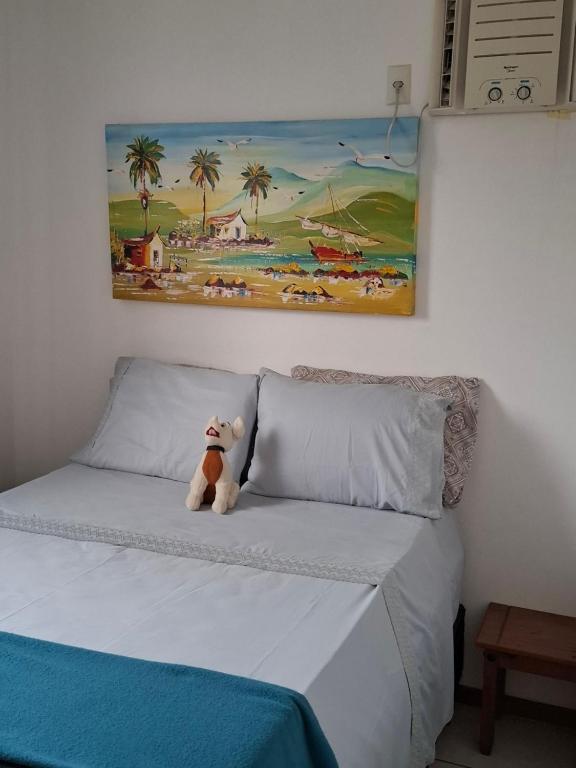 ein Teddybär, der auf einem Bett sitzt in der Unterkunft Apartamento linda vista para o mar Penha Parque Beto Carrero in Penha