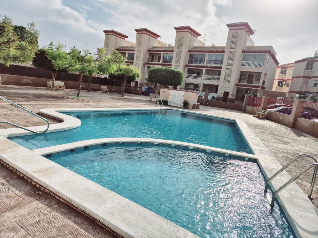 a swimming pool in front of a building at Appartement cosy avec 2 chambres et piscine commune in San Pedro del Pinatar