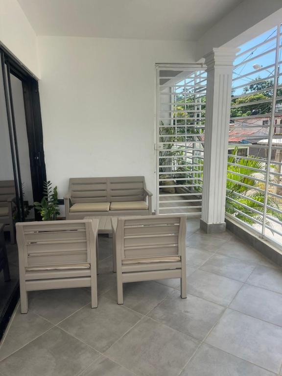 a room with two benches and a table and a balcony at La Villa Salma in Santa Bárbara de Samaná