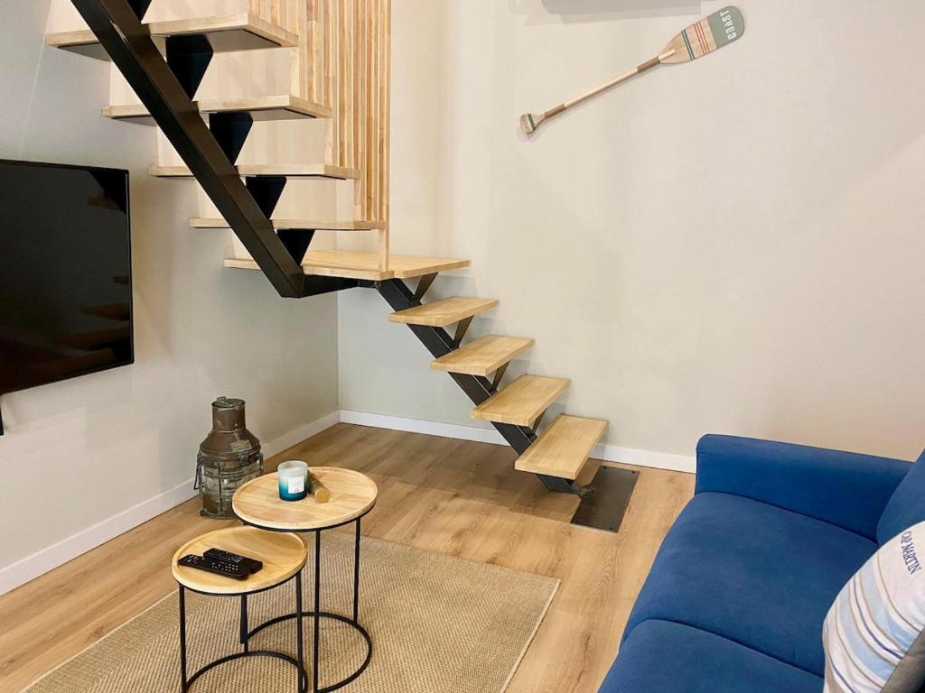 - un salon avec un canapé bleu et des escaliers en bois dans l'établissement 'La Perrière' Joli T2 en duplex Clim, Wifi, à Sète