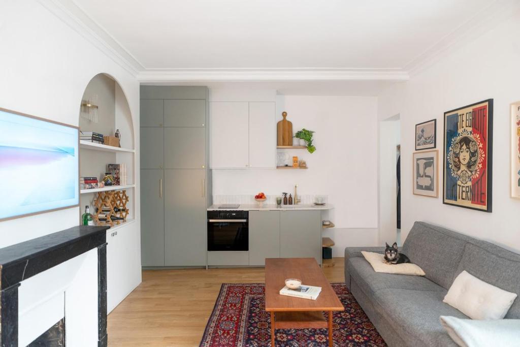 un salon avec un canapé et une table dans l'établissement Minimalist Haussmannian Paris 11, à Paris