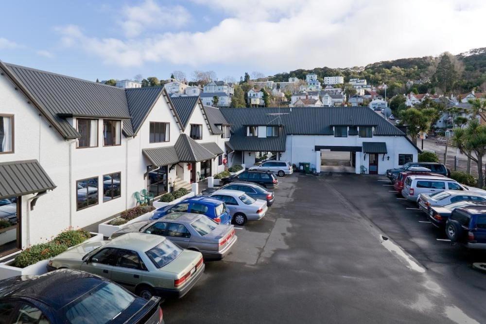 een rij auto's geparkeerd op een parkeerplaats bij Allan Court Motel in Dunedin