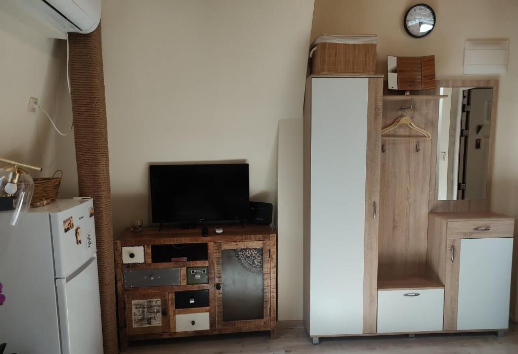 a room with a refrigerator and a tv on a table at Dream Loft in the center of Varna in Varna City