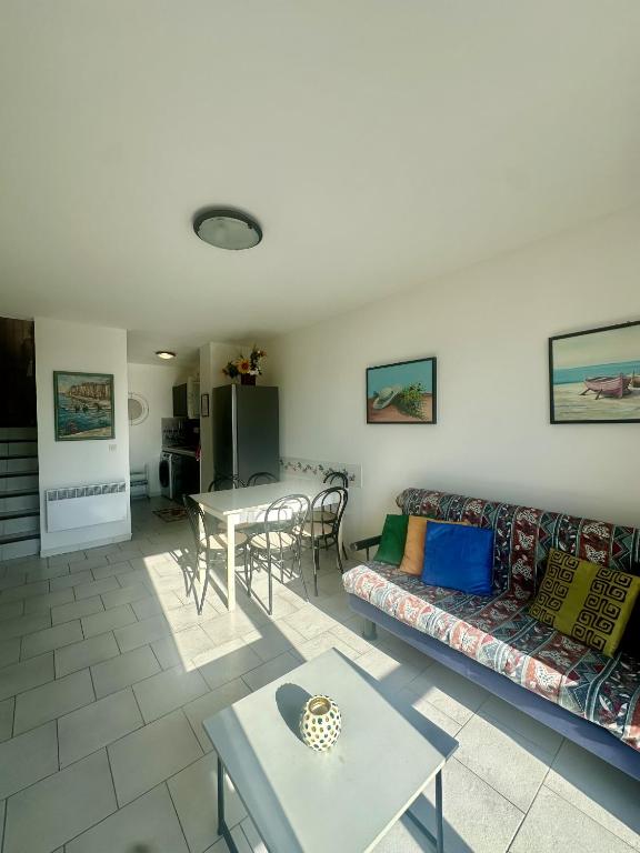 un salon avec un canapé et une table dans l'établissement Appartement vue mer à Ile Rousse avec parking privé, à LʼÎle-Rousse