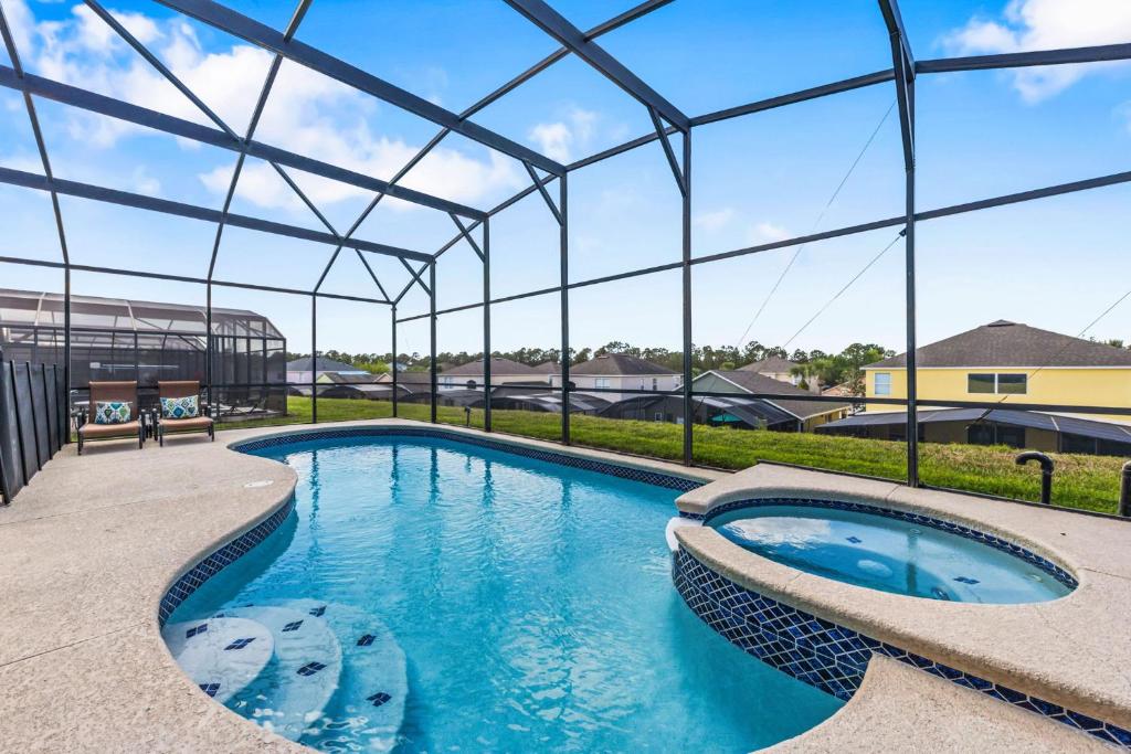 a large swimming pool with a large glass roof at 7BDM Prvt Pool Villa - Gated Resort 10min to Disney in Kissimmee