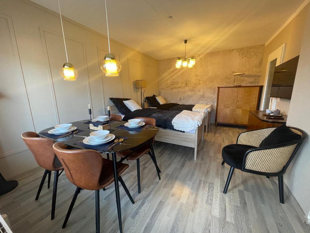 a room with a table and chairs and a bed at Stylisches City Apartment mit Balkon und Garage in Leipzig
