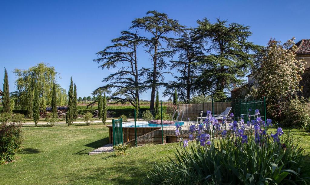 un jardin avec une piscine et des fleurs violettes dans l'établissement La Métairie Du Clos Saint Louis, 4 chambres pour 8 personnes, à Montréal