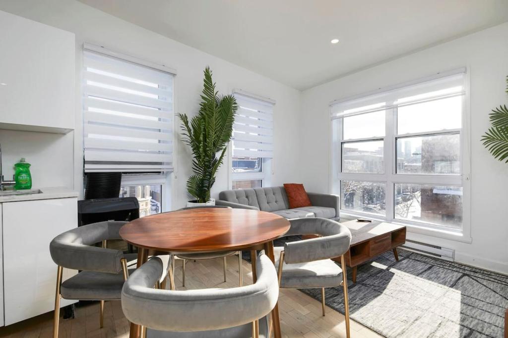 a living room with a wooden table and chairs at Contemporary 2BR Retreat in MTL Village in Montréal