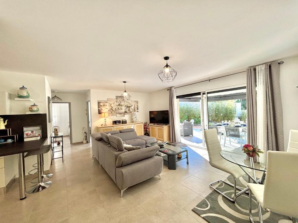 un salon avec un canapé, des chaises et une table dans l'établissement Villa Le Rotolo PORTICCIO, à Porticcio