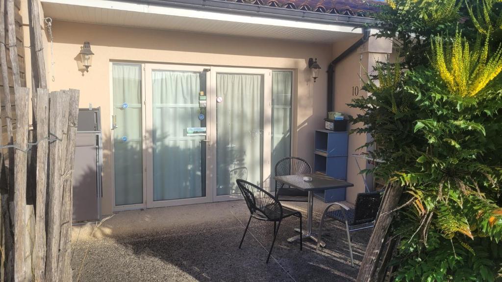 a patio with a table and chairs in front of a door at Hotel La Peyrade in Cajarc