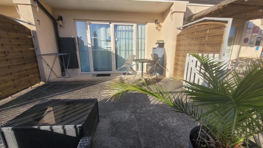 a patio with a chair and a table and plants at Hotel La Peyrade in Cajarc