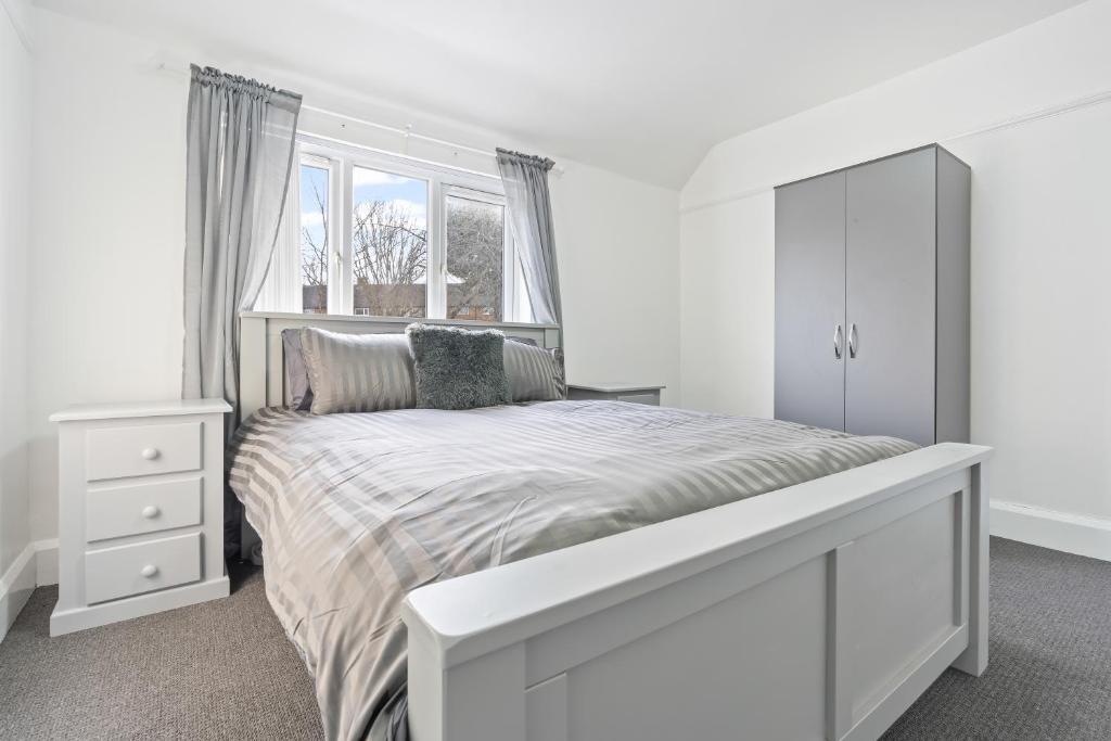 a white bedroom with a bed and a window at Abbie's House in Nottingham