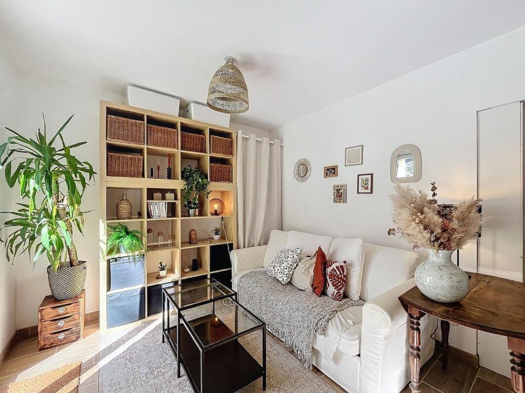 un salon avec un canapé blanc et une table dans l'établissement Cozy garden apartment - Caen, à Caen