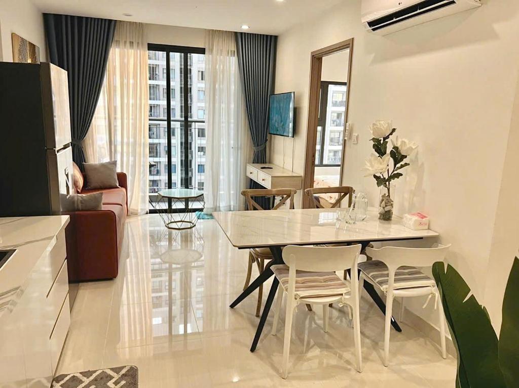 une cuisine et un salon avec une table et des chaises dans l'établissement Shi House -2BR Building S901 Cozy & Comfy Stay, à Long Bình